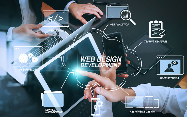 Two people work on laptops and a tablet, surrounded by digital icons and keywords like Web Design Development, Web Analytics, Responsive Design, and Content Management..